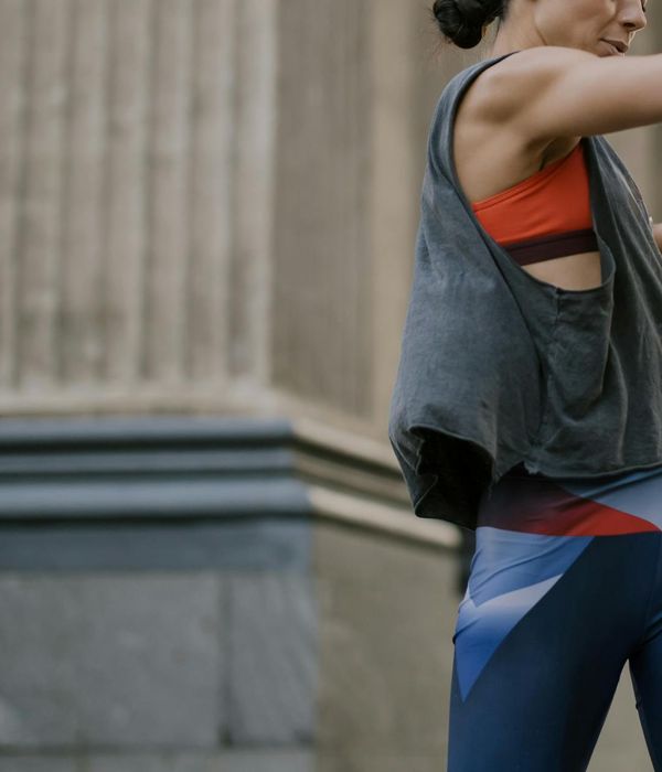 Woman in activewear performing a dynamic cardio movement in a modern studio.